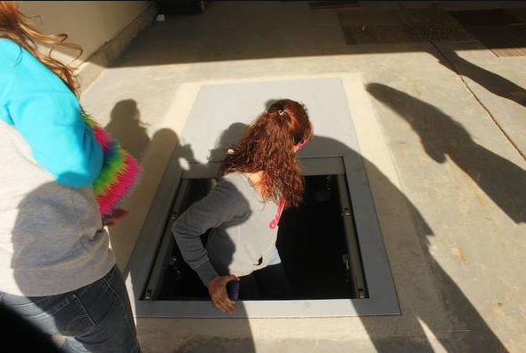 A lady entering a garage underground shelter