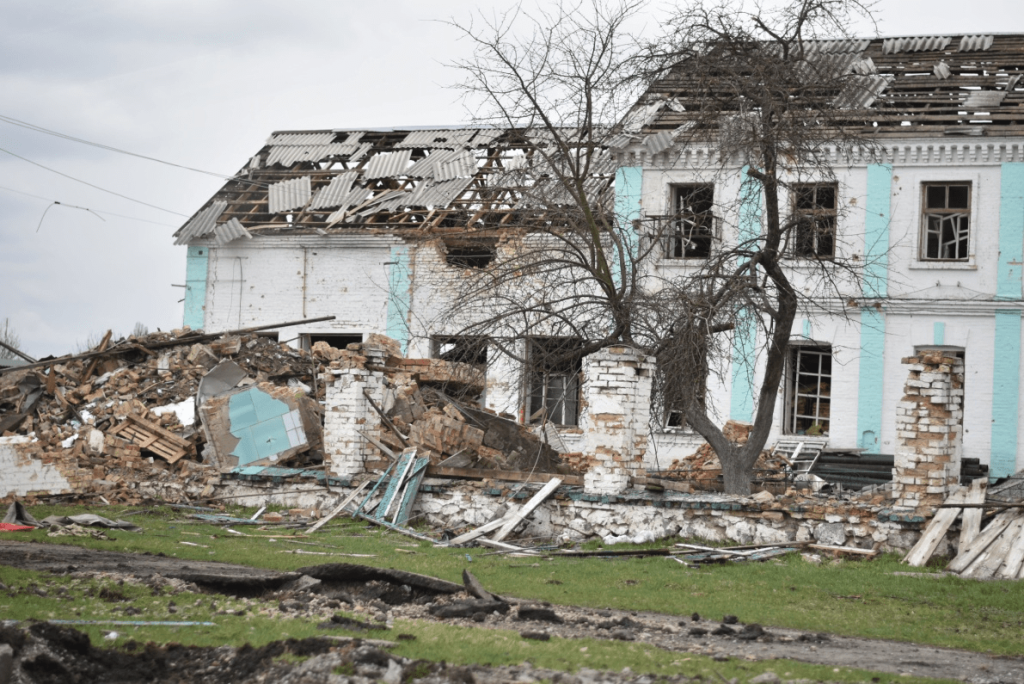 debris of a damaged house piled up on the ground.