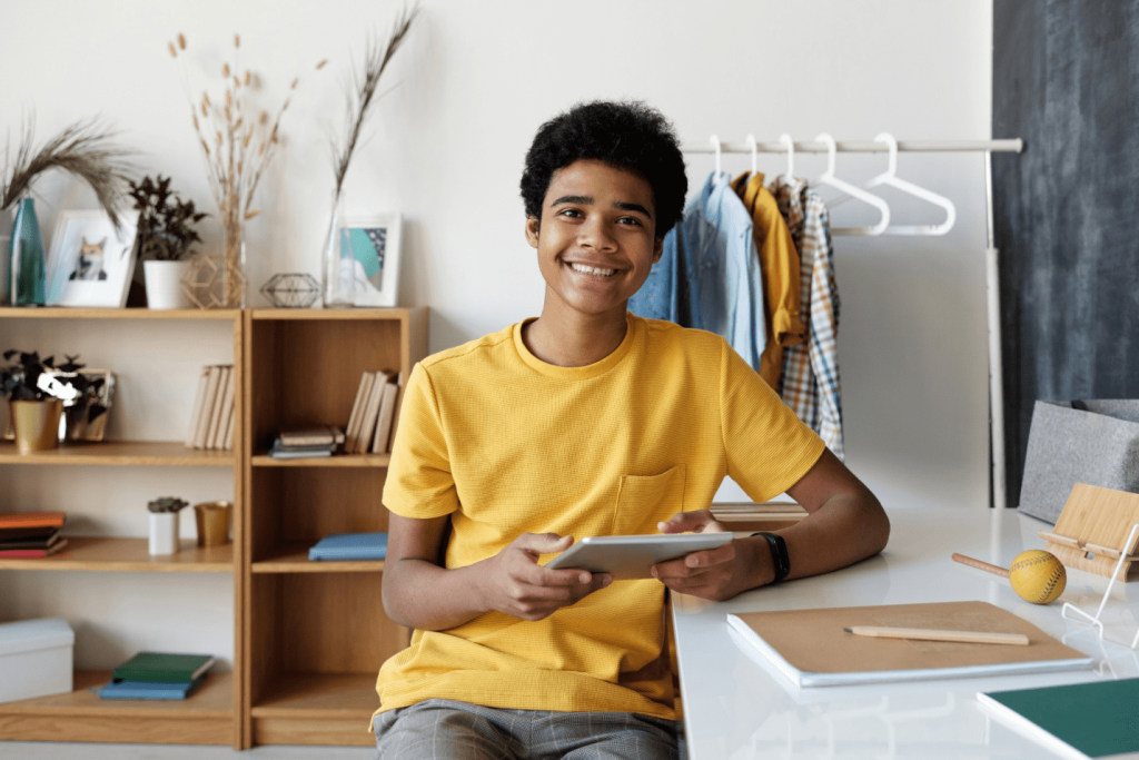 Boy in yellow crew neck shirt sitting on chair