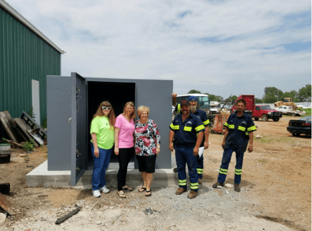 A family posing with Oklahoma Shelters crew