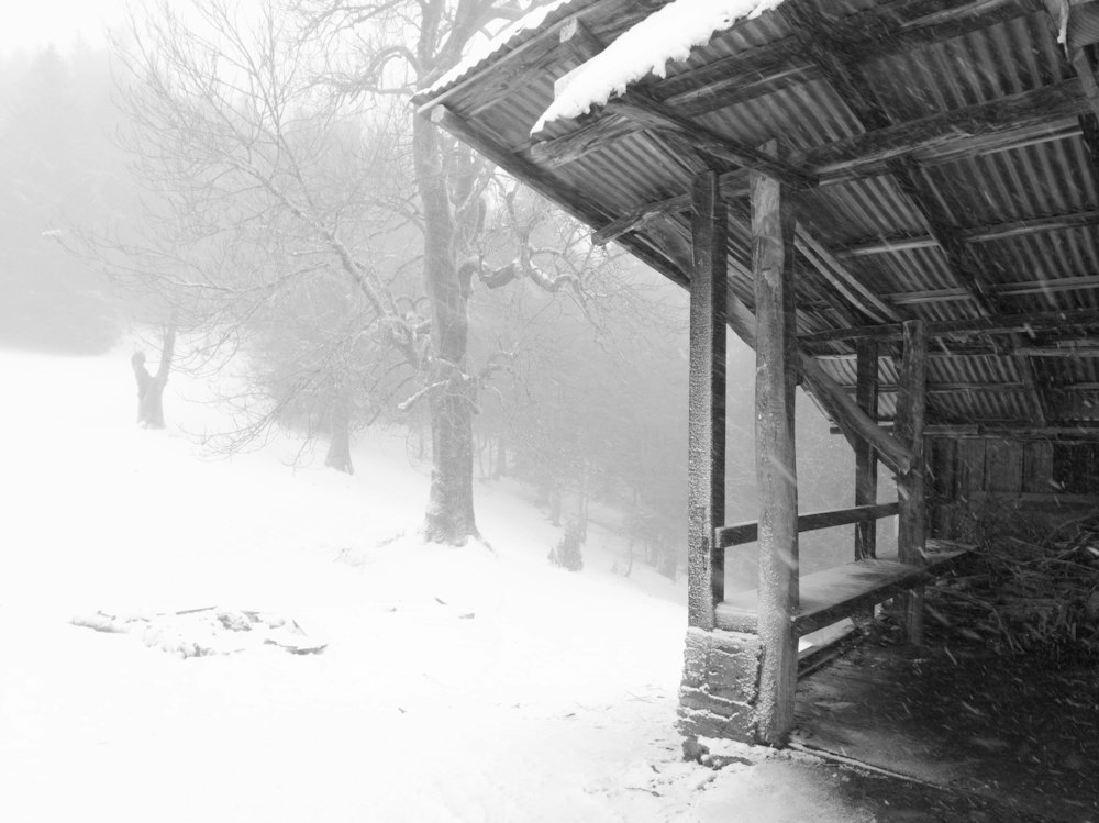 An old storm shelter covered in a blizzard