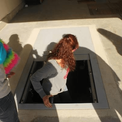 An image of a person entering an underground storm shelter.