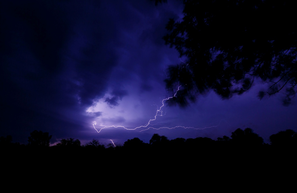 Bright lightning bolts cutting across a dark night sky during a severe storm