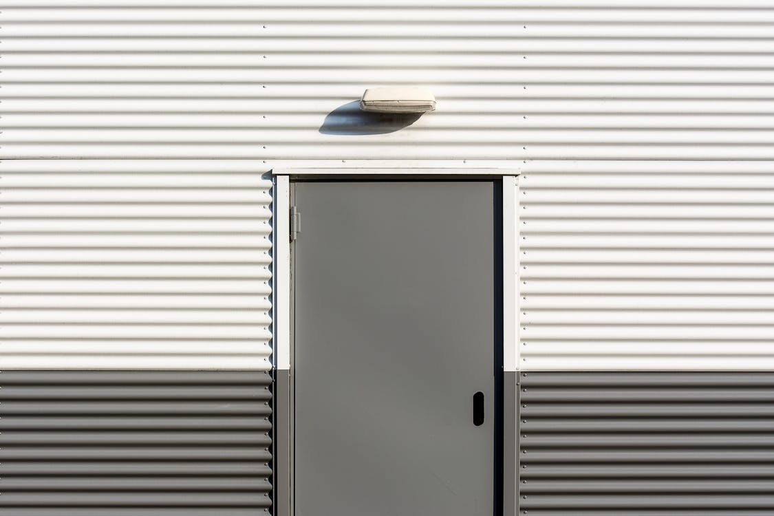 Sturdy exterior door built into a siding-covered wall.
