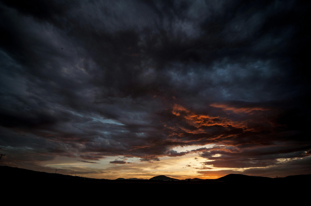 Dark silhouette of Oklahoma mountains under heavy storm clouds
