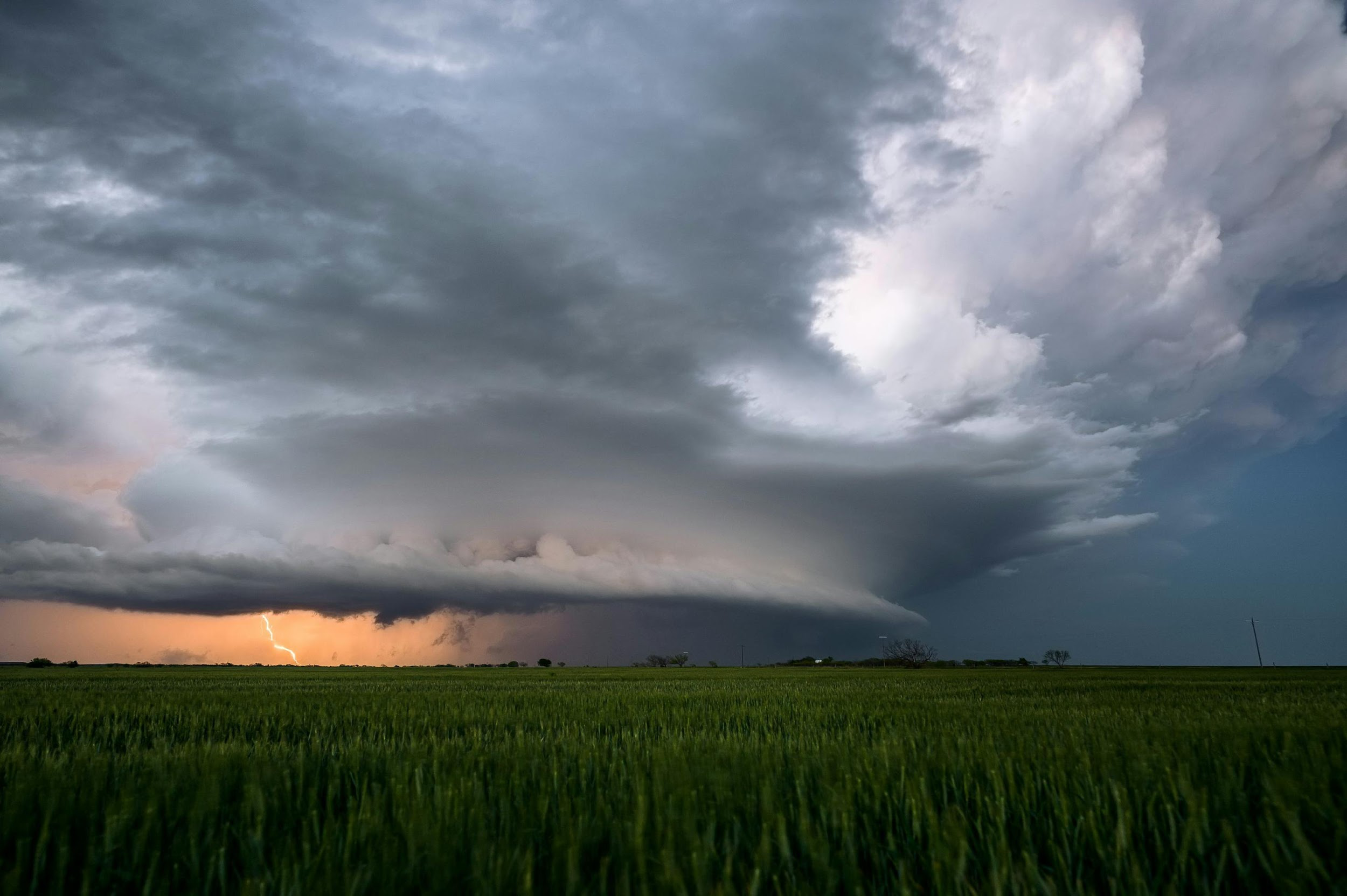 Storm approaching over a wide green field