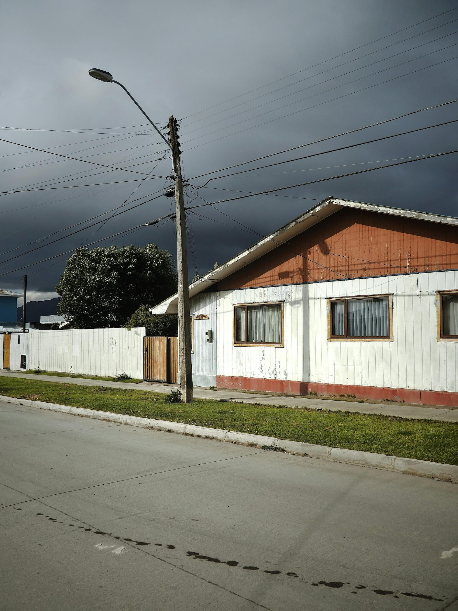 White and brown wooden house under a stormy sky in Oklahoma