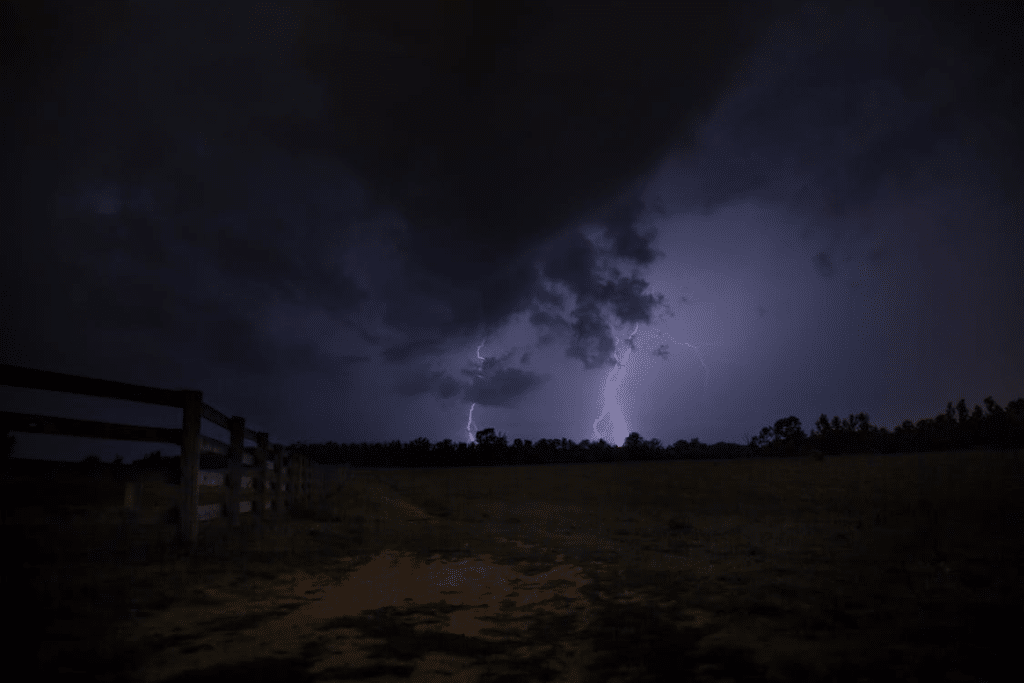Severe storm with lightning striking over an open field at night in Oklahoma