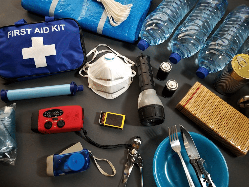 Emergency supplies including a first aid kit, water bottles, flashlight, radio, and essential safety items.