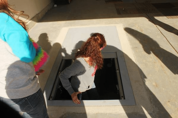 In ground storm shelter with open entry.