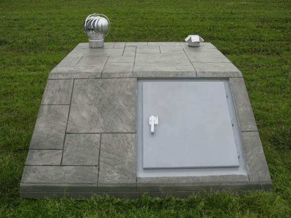 In-ground storm shelter with secure door and ventilation system.