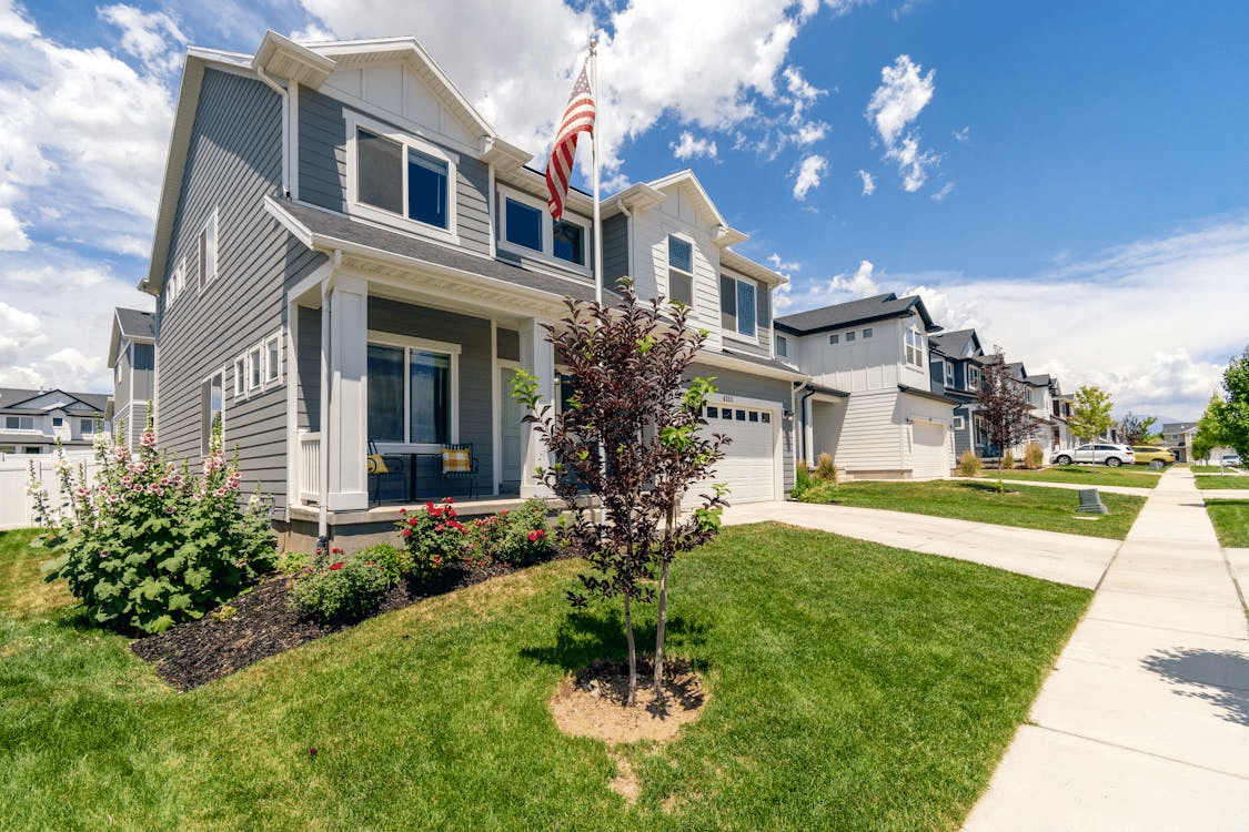Modern suburban house with a garage and American flag on a sunny day