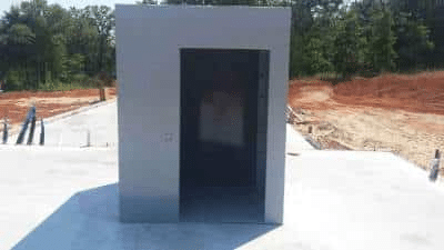 Above-ground storm safe room installed on a concrete foundation at a residential construction site.