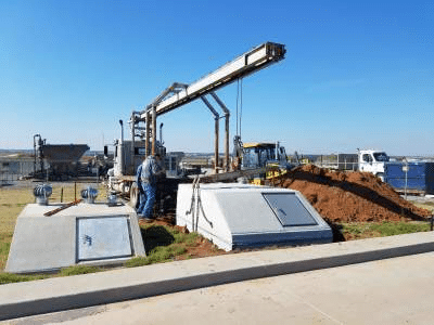 An image shows two underground storm shelters in the process of installation.