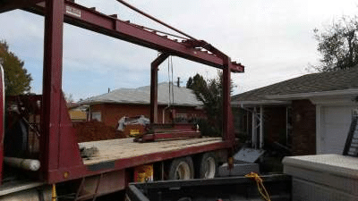Delivery truck positioned at a residential property to install a shelter.