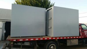 A steel safe room being transported on a truck