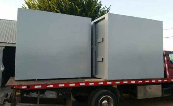 A steel safe room being transported on a truck