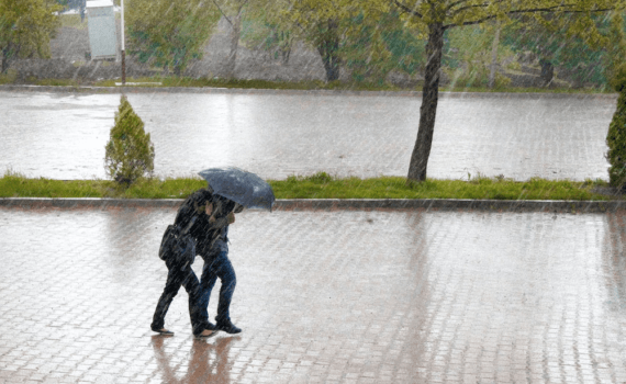 Two people walking with an umbrella in the rain.