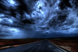Dark and morbid looking storm clouds looming over a deserted road