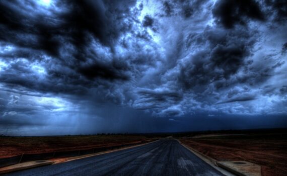 Dark and morbid looking storm clouds looming over a deserted road
