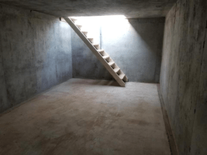 Inside of an underground cement shelter with a staircase.