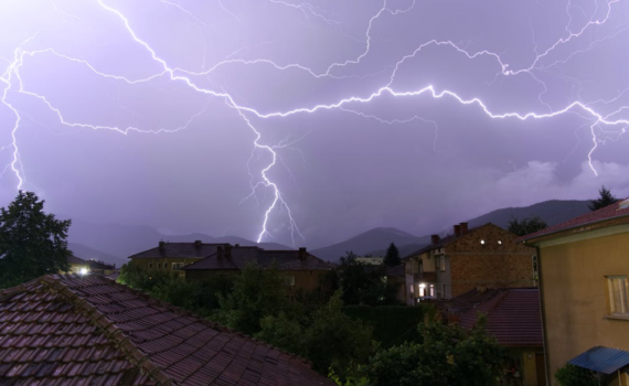 lightning striking over homes