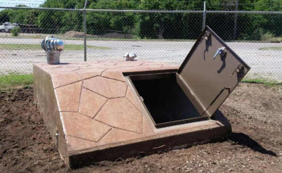 A concrete underground bunker with the door opened