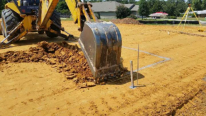 An excavator digging the ground along the lines of a bunker
