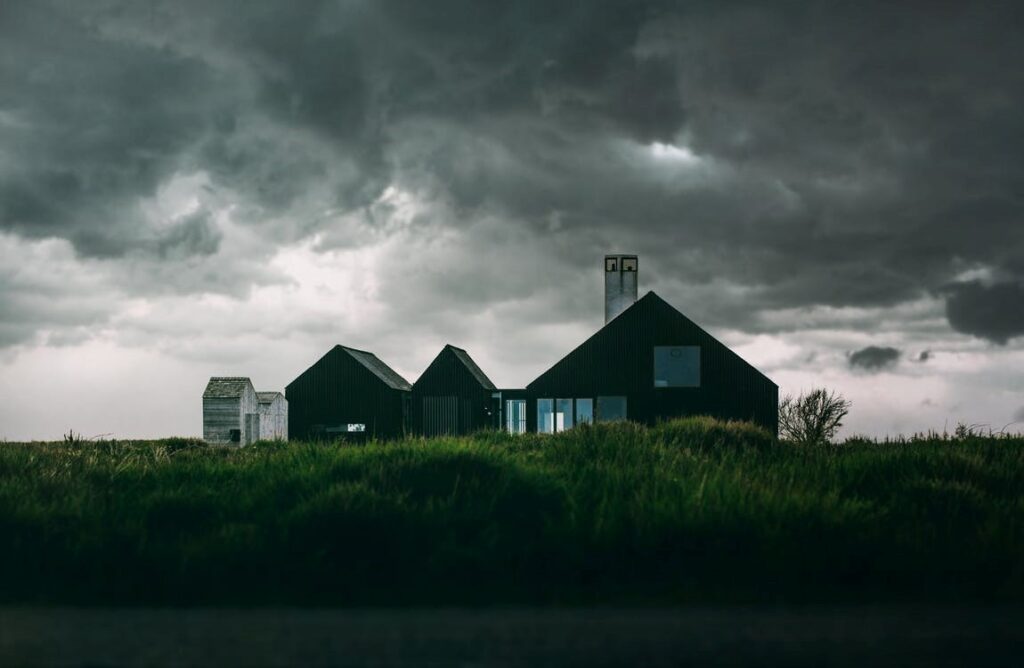Dark storm clouds over a black and white house