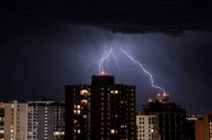 lightning strike buildings in the night sky